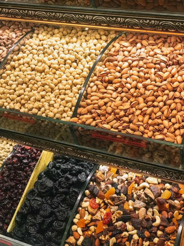 gallery-5 Colorful assortment of nuts and dried fruits in a market display, showcasing healthy snack options.