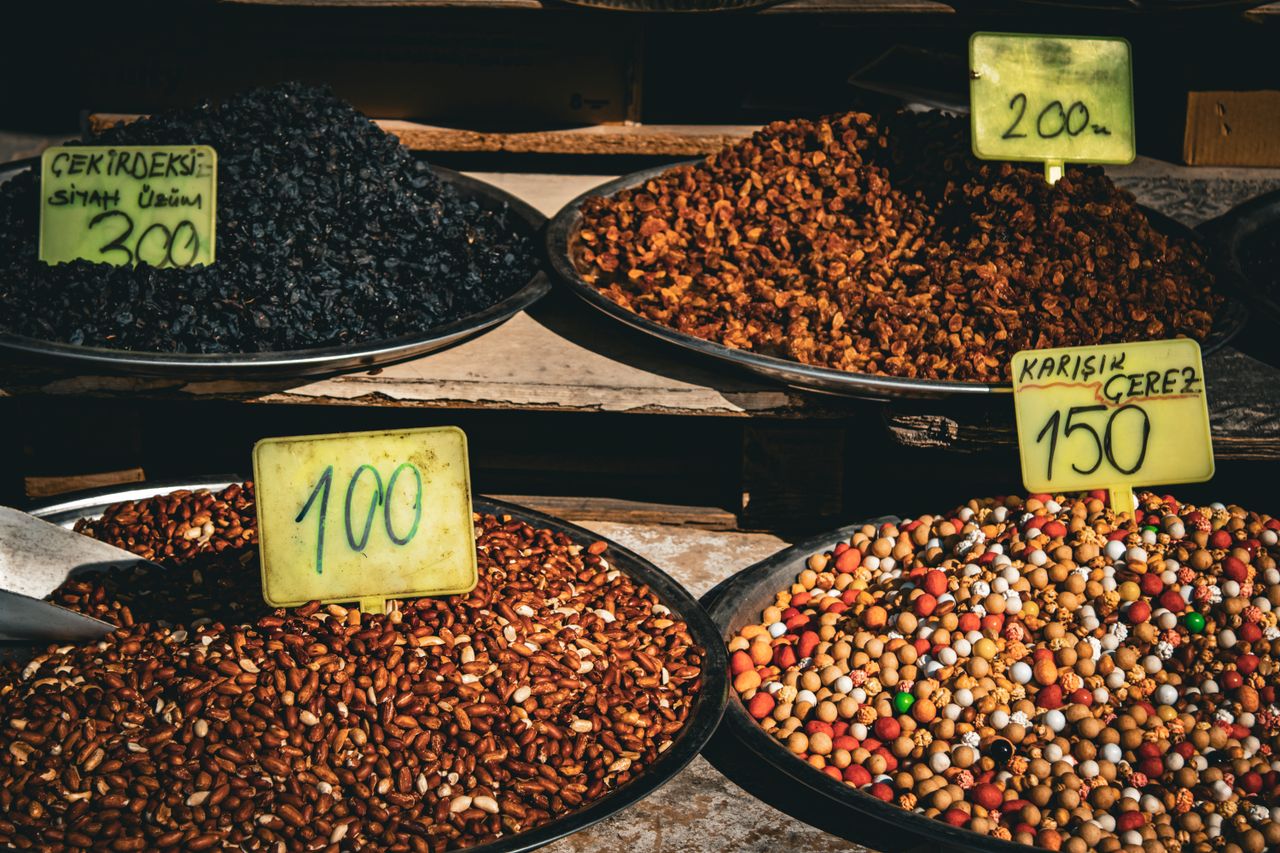 services-01 Colorful display of dried fruits and nuts in market with price tags, ideal for culinary and travel themes.