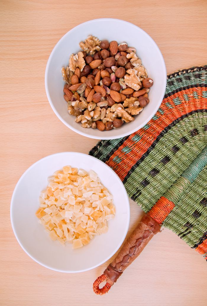 gallery-1 Top view of dried fruits and mixed nuts in bowls on a wooden table.