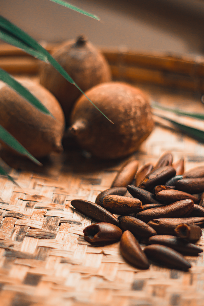 why-choose-us Detailed view of various brown fruits and nuts arranged on a woven mat.